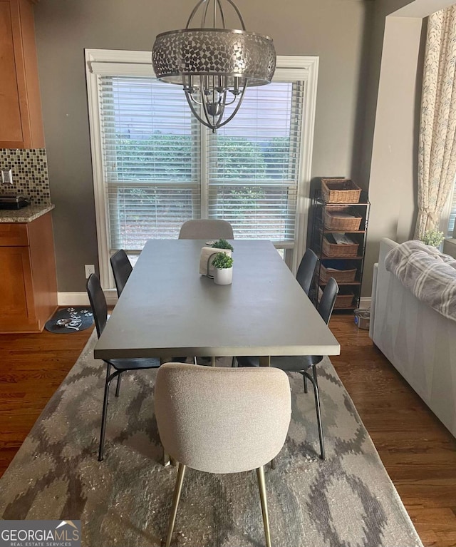 dining space with plenty of natural light, dark hardwood / wood-style floors, and a notable chandelier