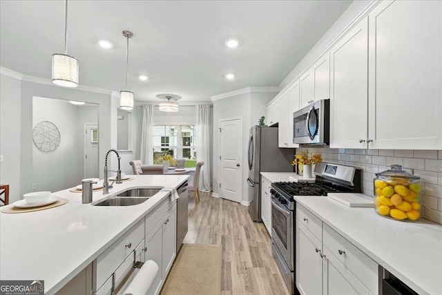 kitchen with sink, stainless steel appliances, decorative light fixtures, decorative backsplash, and white cabinets