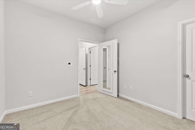 empty room with ceiling fan and light colored carpet