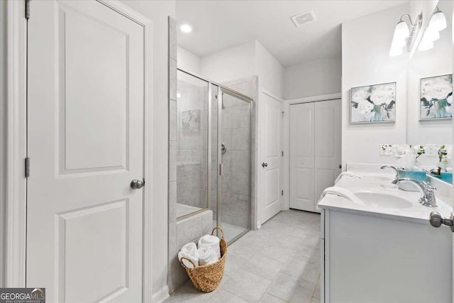 bathroom featuring a shower with door, vanity, and tile patterned flooring