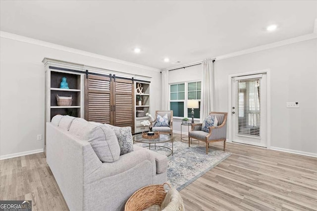 living room featuring built in shelves, ornamental molding, and light hardwood / wood-style flooring