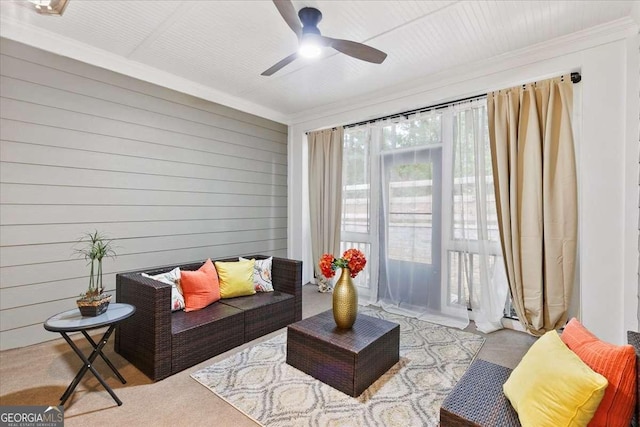 living room with ceiling fan, ornamental molding, and wood walls