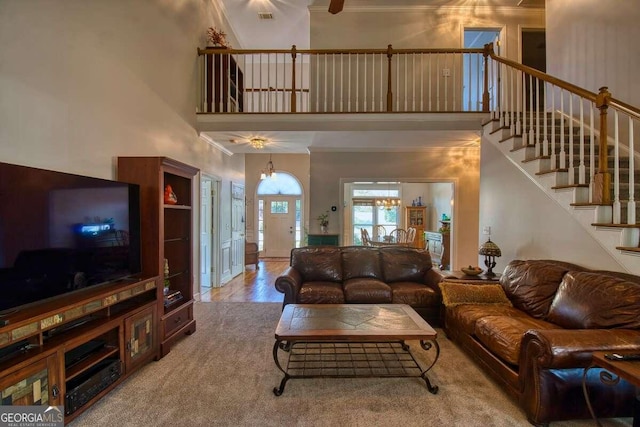 living room featuring a towering ceiling, carpet floors, and an inviting chandelier