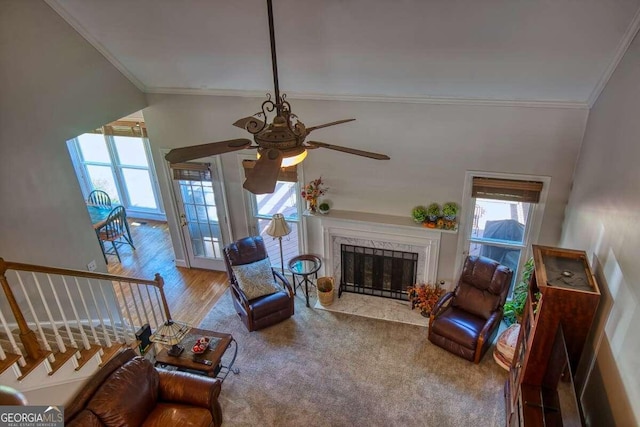 living room with a fireplace, hardwood / wood-style floors, ceiling fan, and crown molding