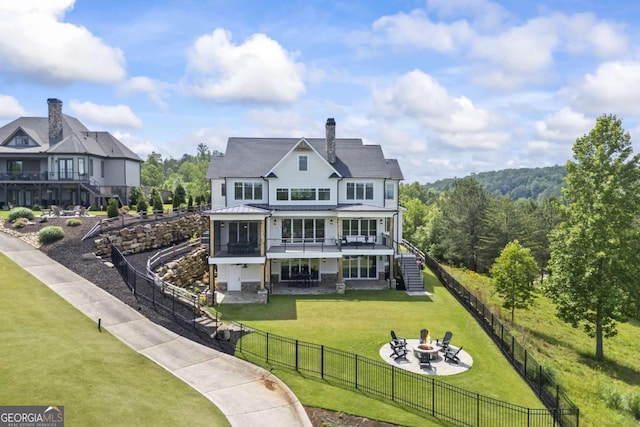 back of house featuring a fire pit, a sunroom, a patio area, and a yard