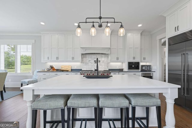 kitchen featuring a center island, dark hardwood / wood-style floors, decorative light fixtures, white cabinetry, and stainless steel appliances