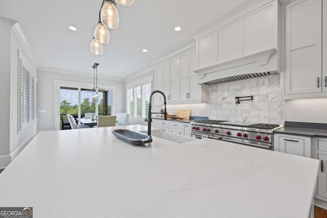 kitchen with white cabinetry, sink, double oven range, and decorative light fixtures