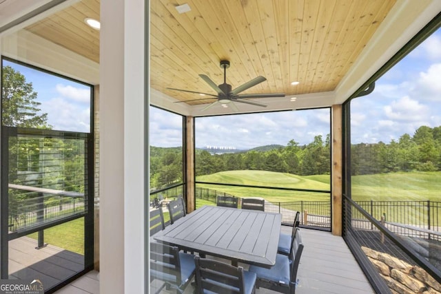 sunroom / solarium with ceiling fan and wood ceiling