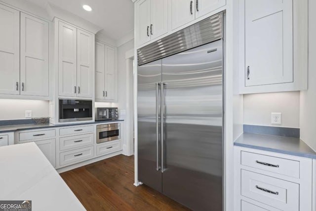 kitchen featuring white cabinetry, built in fridge, and dark wood-type flooring