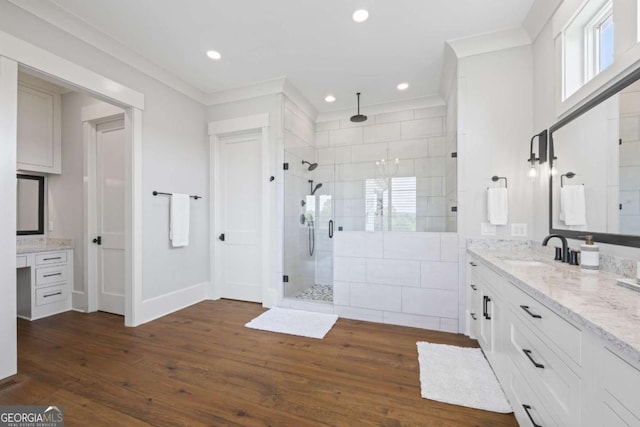 bathroom featuring vanity, hardwood / wood-style flooring, an enclosed shower, and crown molding