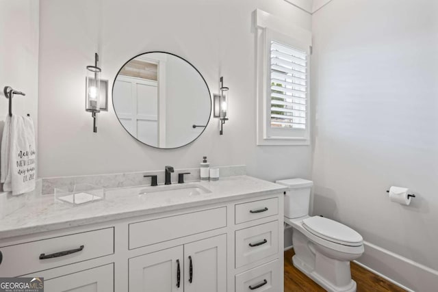 bathroom with hardwood / wood-style flooring, vanity, and toilet