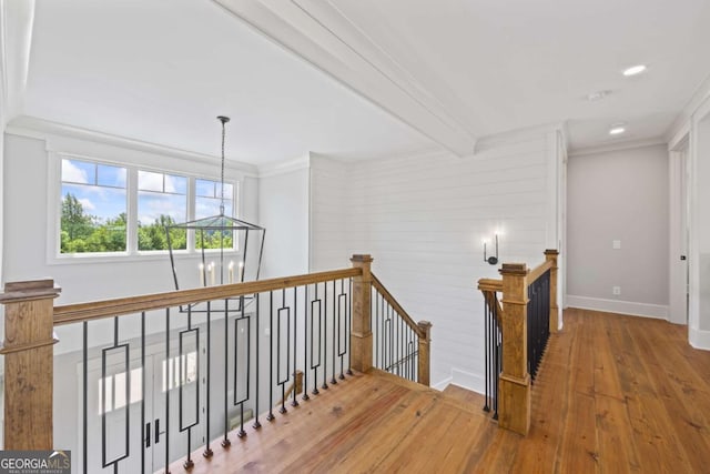 corridor featuring crown molding, hardwood / wood-style floors, and beamed ceiling