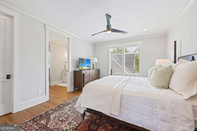 bedroom featuring ceiling fan, crown molding, ensuite bathroom, and light wood-type flooring