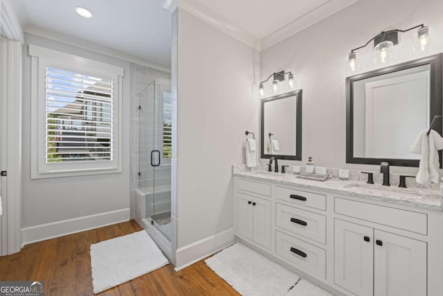 bathroom with hardwood / wood-style floors, vanity, an enclosed shower, and crown molding