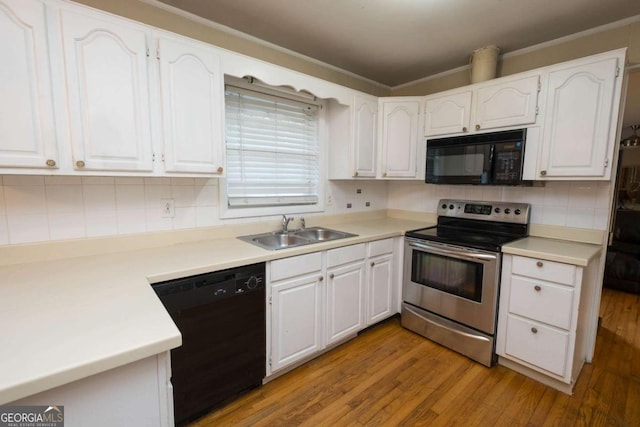 kitchen with sink, light hardwood / wood-style flooring, backsplash, white cabinets, and black appliances