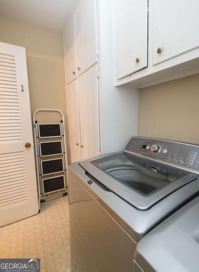 laundry area featuring cabinets and washing machine and clothes dryer