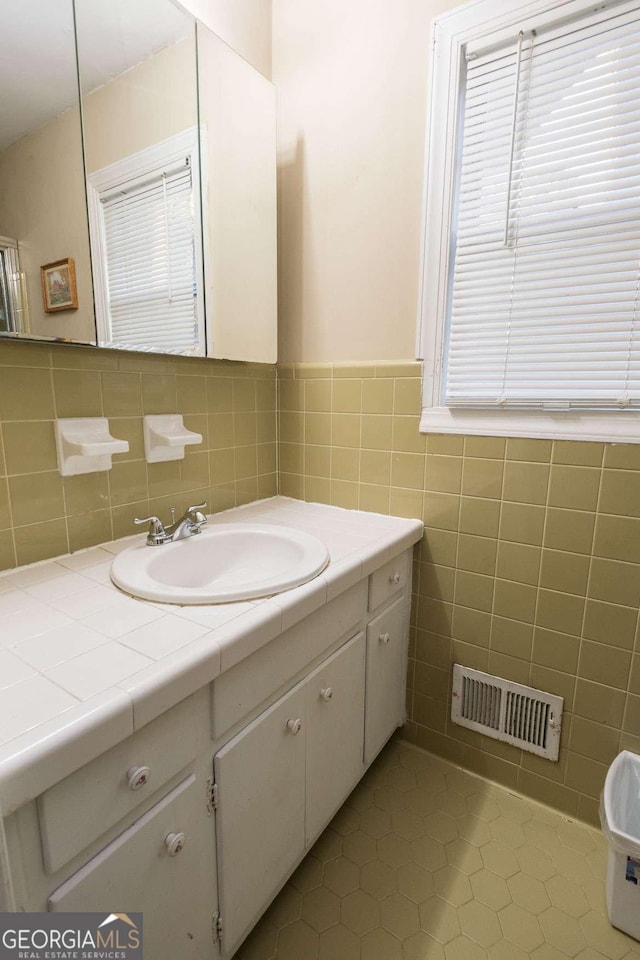 bathroom featuring tile patterned flooring, vanity, and tile walls