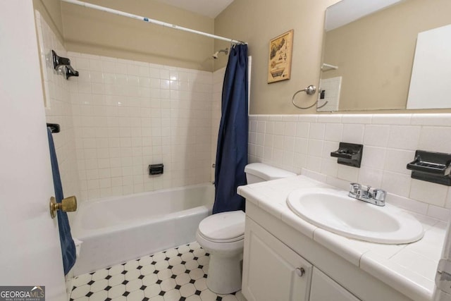 full bathroom with shower / tub combo with curtain, vanity, tile walls, and toilet