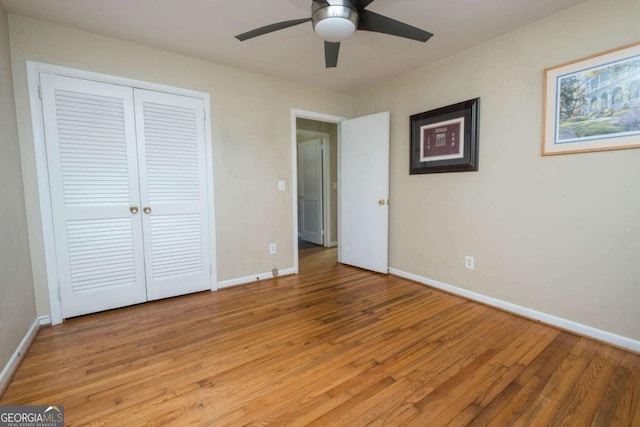 unfurnished bedroom featuring ceiling fan, light wood-type flooring, and a closet