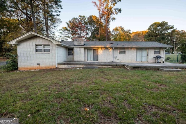 back of house featuring a patio and a lawn