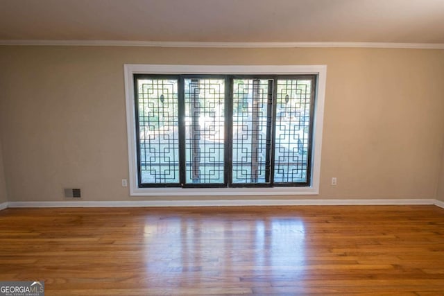 unfurnished room with crown molding and hardwood / wood-style flooring