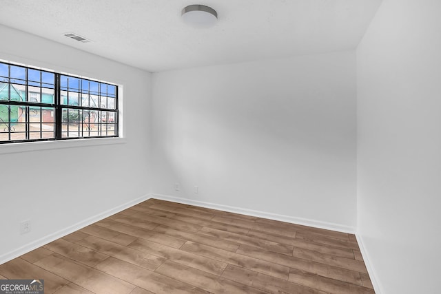 unfurnished room with hardwood / wood-style floors