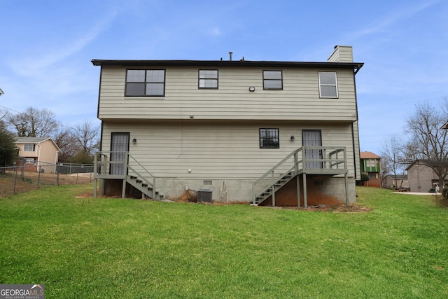 back of house featuring central AC unit and a lawn