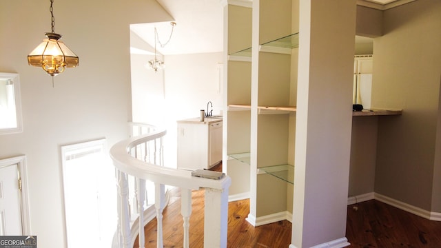 staircase featuring a chandelier, wood-type flooring, and sink