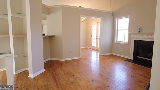 unfurnished living room with vaulted ceiling and light hardwood / wood-style flooring