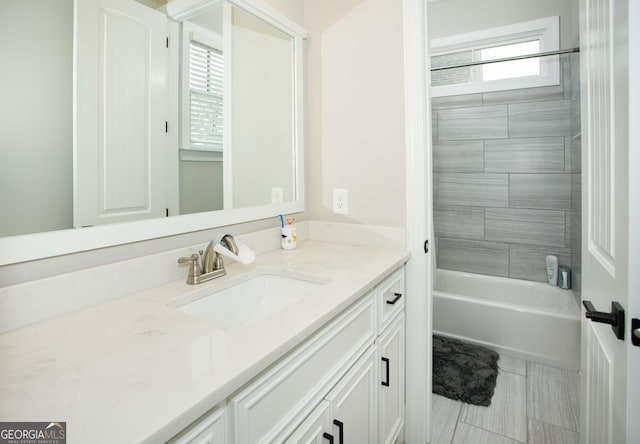 bathroom featuring tile patterned flooring, vanity, and tiled shower / bath