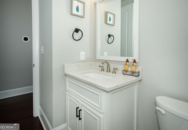 bathroom with vanity, wood-type flooring, and toilet