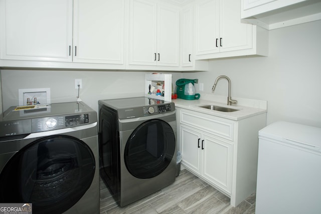 clothes washing area with cabinets, independent washer and dryer, and sink