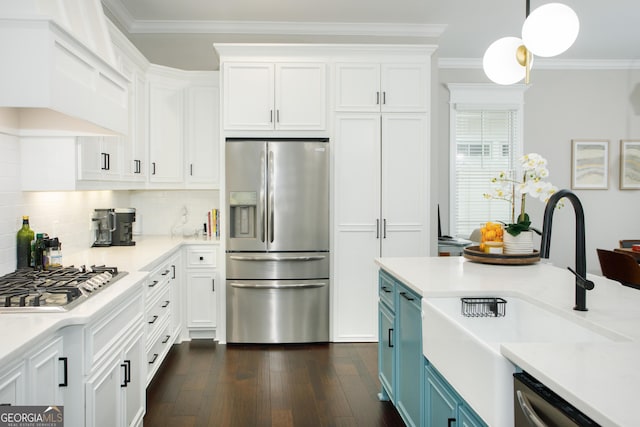 kitchen with white cabinetry, sink, hanging light fixtures, blue cabinets, and appliances with stainless steel finishes