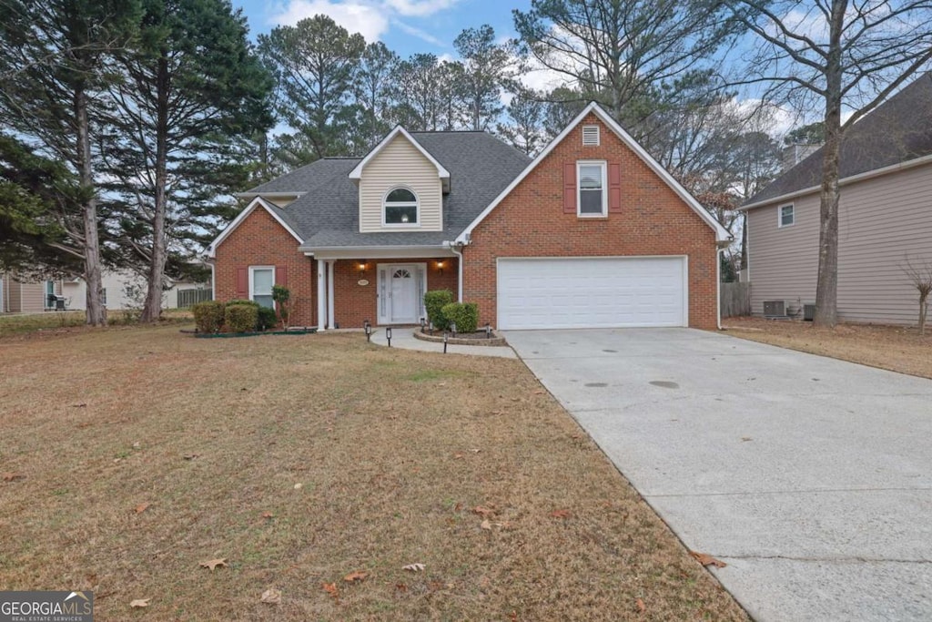 view of front property featuring cooling unit, a garage, and a front lawn