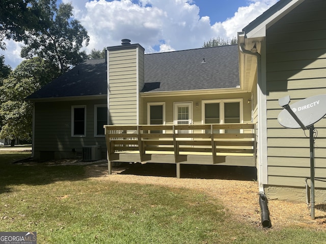 rear view of property featuring a yard, a deck, and central air condition unit