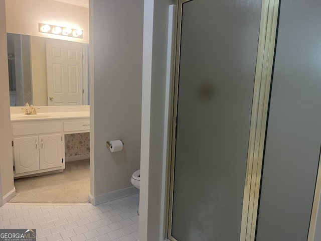 bathroom featuring toilet, vanity, tile patterned floors, and a shower with shower door