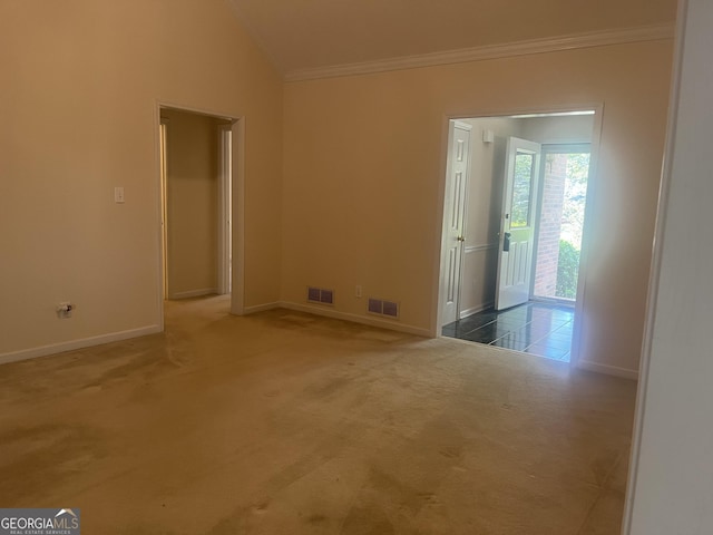 unfurnished room featuring dark colored carpet, ornamental molding, and vaulted ceiling