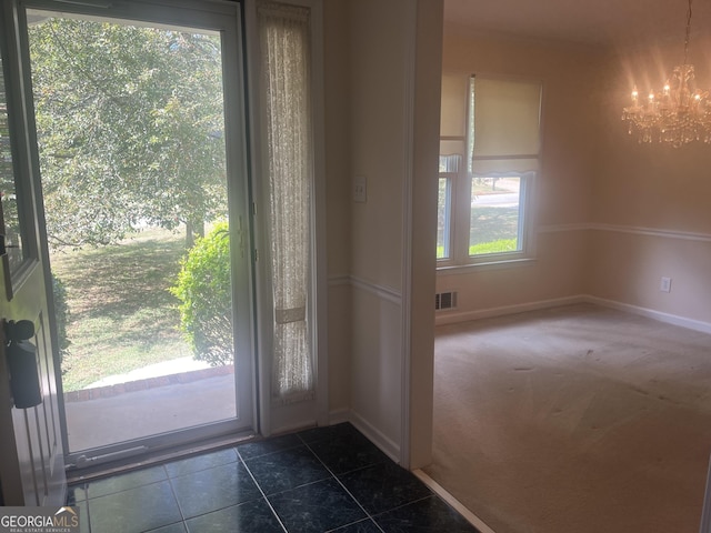 doorway to outside featuring dark colored carpet and a notable chandelier