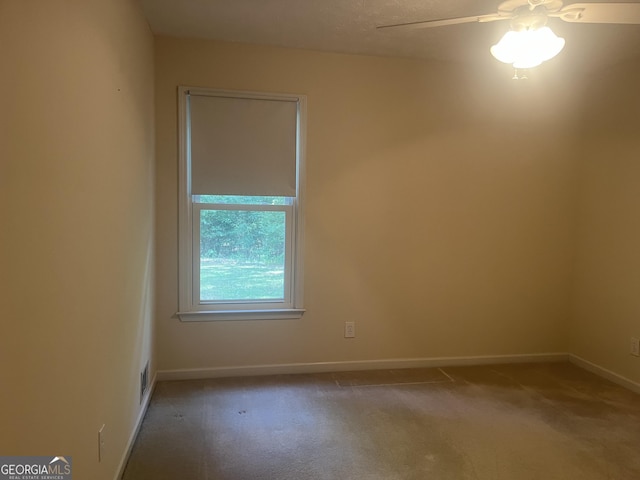 carpeted spare room featuring ceiling fan and a textured ceiling