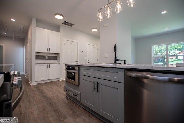 kitchen with tasteful backsplash, white cabinetry, sink, and appliances with stainless steel finishes