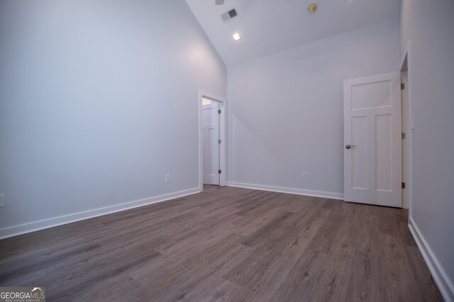 empty room featuring dark hardwood / wood-style flooring and high vaulted ceiling