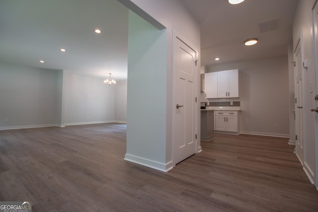 hallway featuring dark wood-type flooring and a chandelier