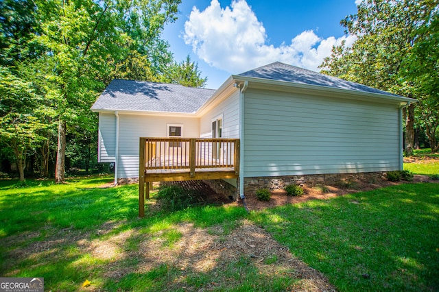 view of property exterior featuring a yard and a wooden deck