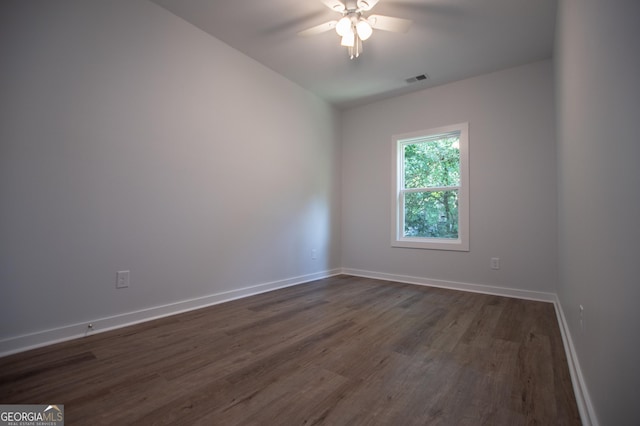 spare room with dark hardwood / wood-style flooring and ceiling fan