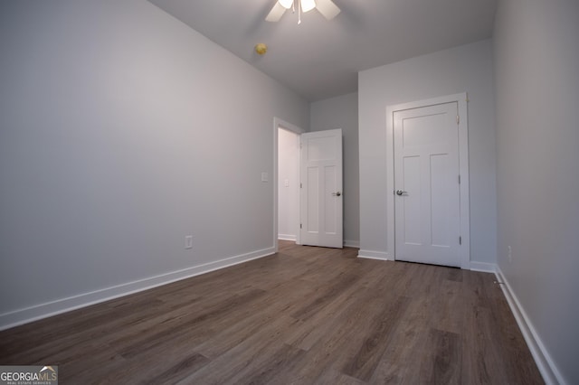 unfurnished bedroom featuring ceiling fan and dark hardwood / wood-style flooring