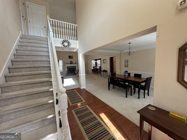 carpeted foyer entrance featuring a high ceiling and a notable chandelier