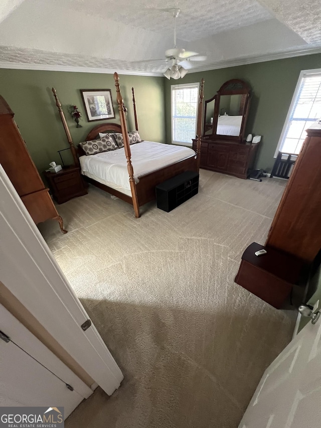 carpeted bedroom featuring ceiling fan, a textured ceiling, and ornamental molding