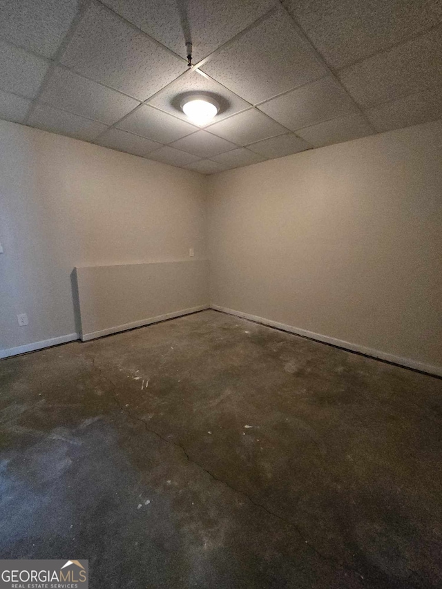 spare room with concrete floors and a drop ceiling