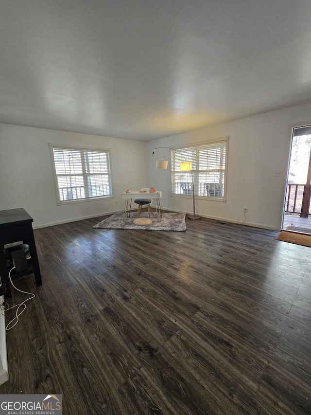 unfurnished living room with dark wood-type flooring