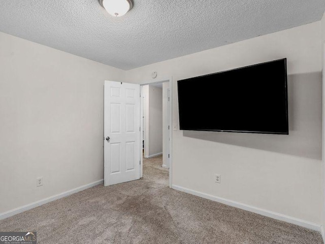 unfurnished room featuring light carpet and a textured ceiling